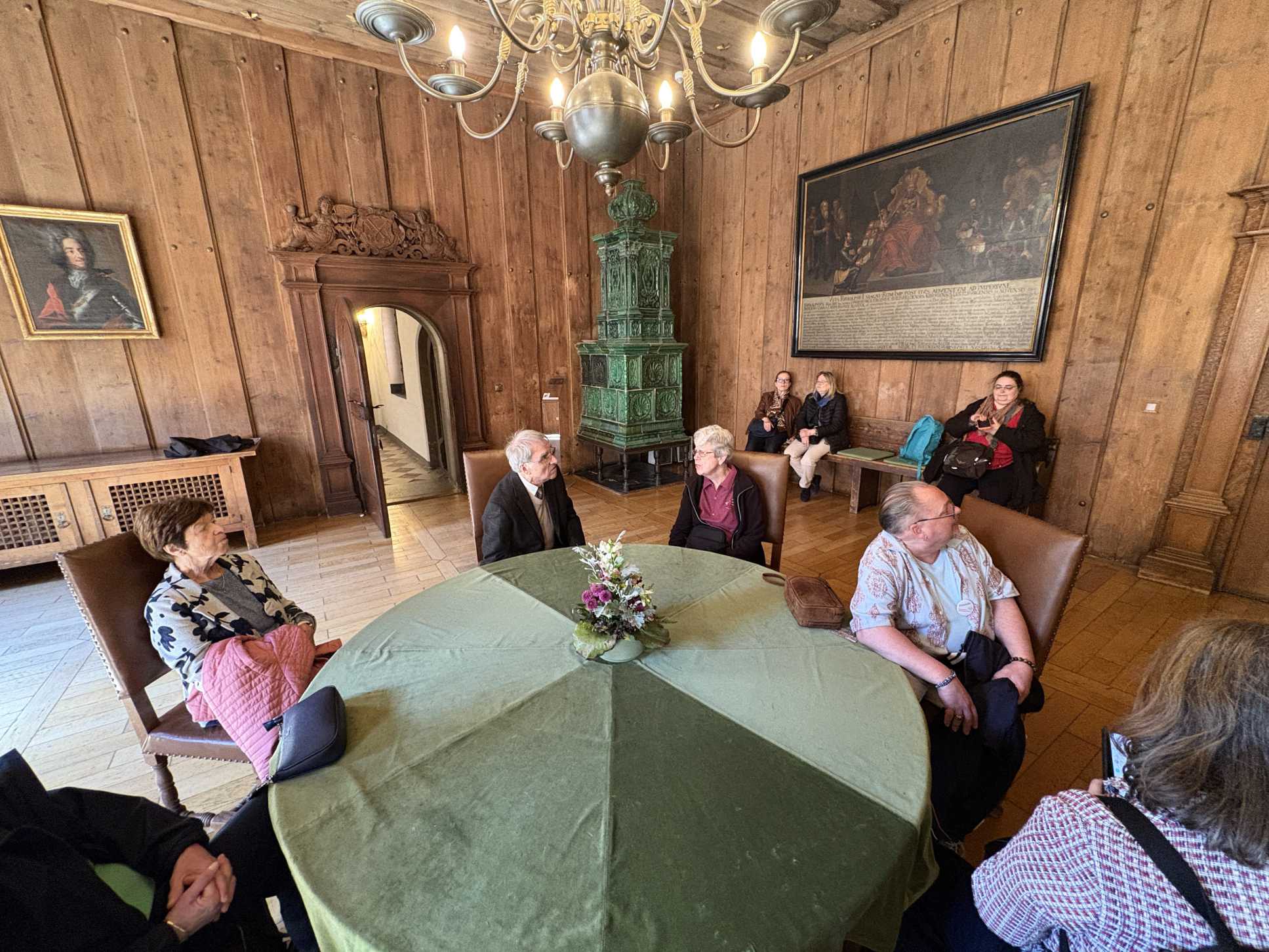 Freundinnen und Freunde des Gärtnerplatztheaters sitzen um einen grünen runden Tisch im Rathaus Regensburg
